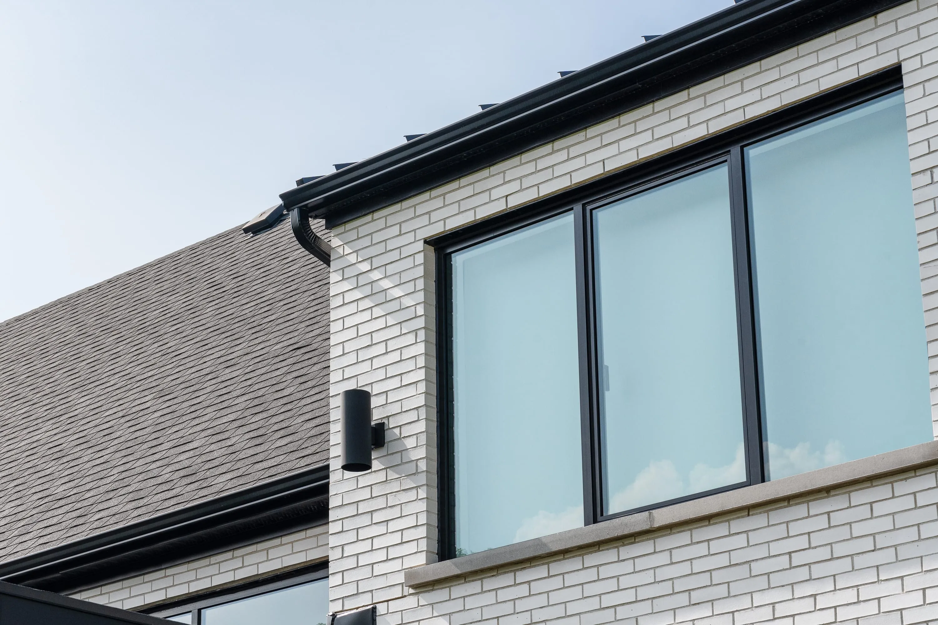 Brick, glazing and roofline detail at Cedar Valley Residence.