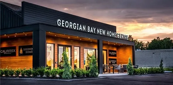 A timber-clad sales centre lit at dusk.