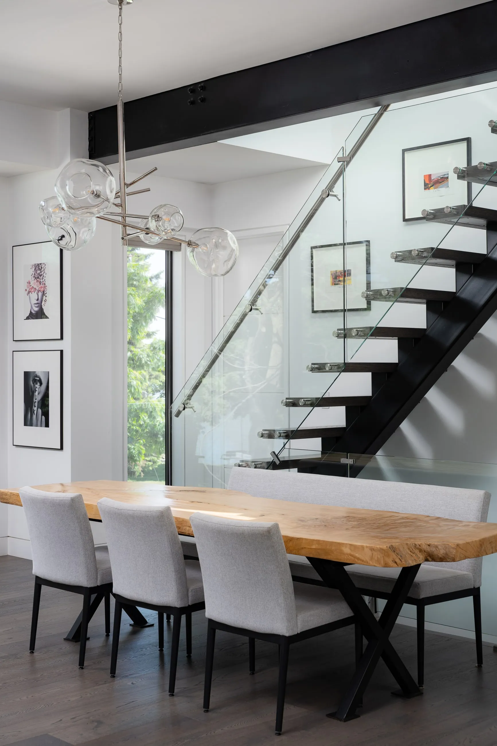 Floating stair treads and a glass balustrade meeting warm timber at Meadow Wood Residence.
