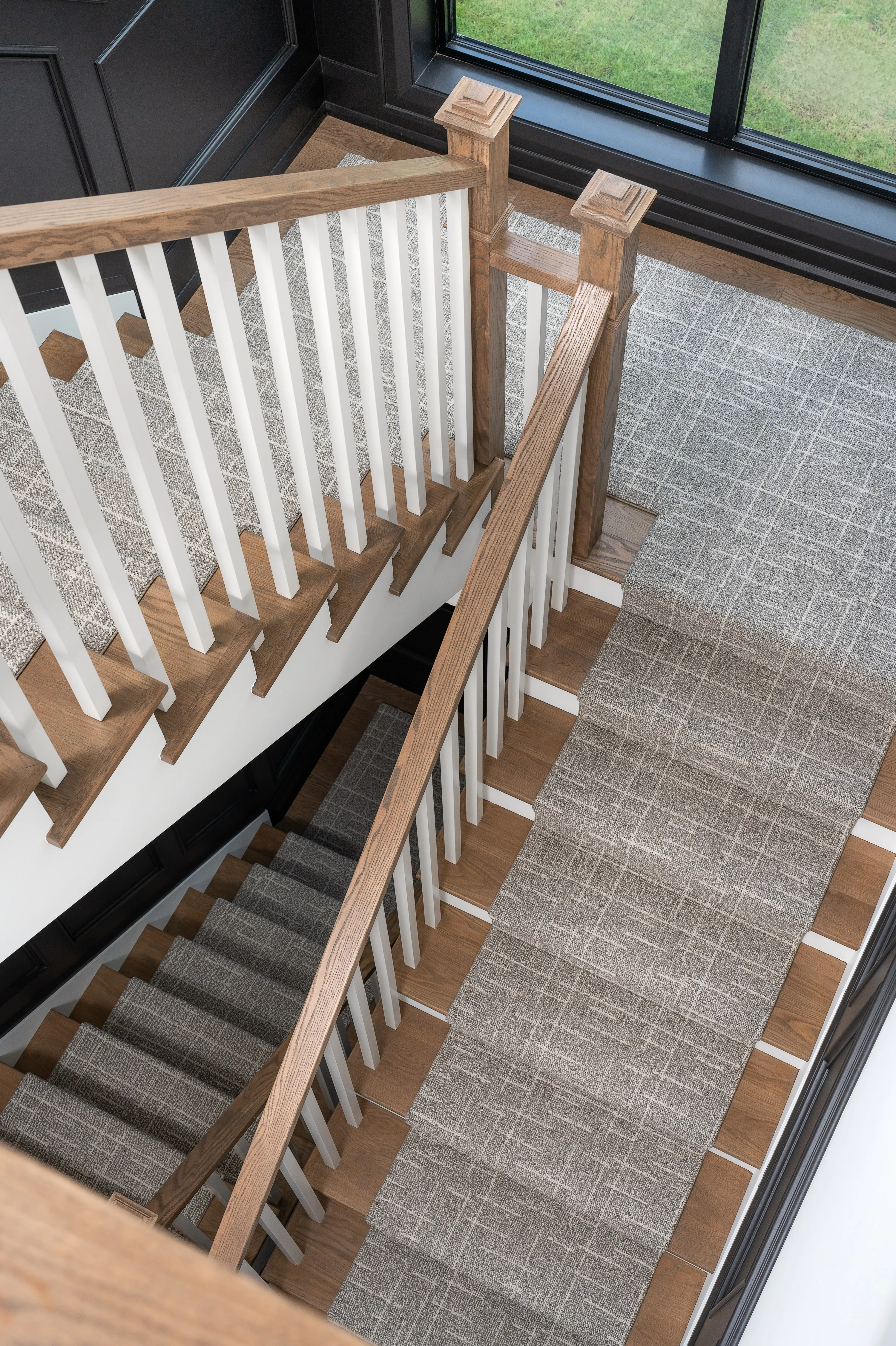 Oak handrails, a woven runner and crisp wall panelling.