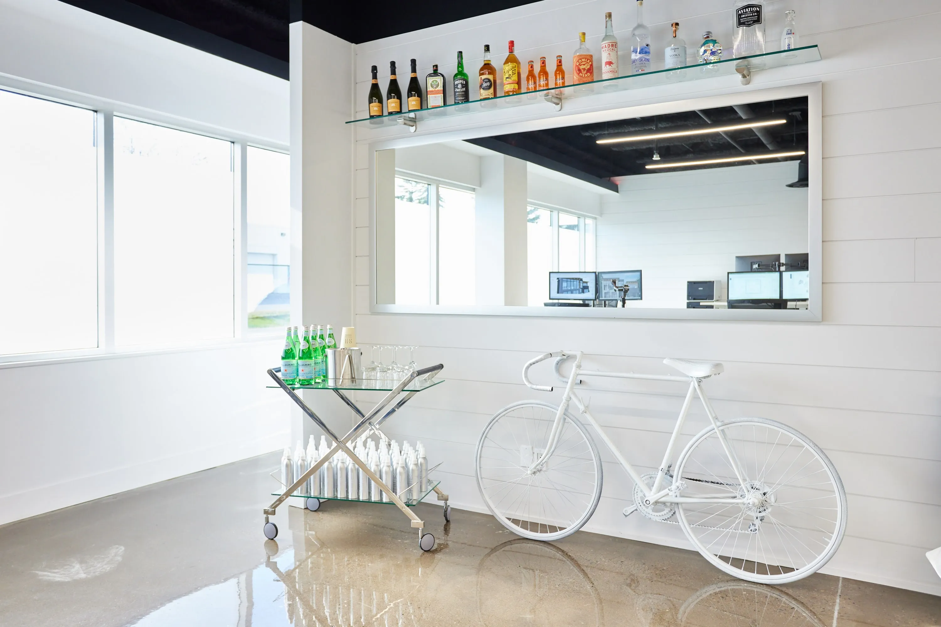 A white bicycle against a shiplap wall in the studio.