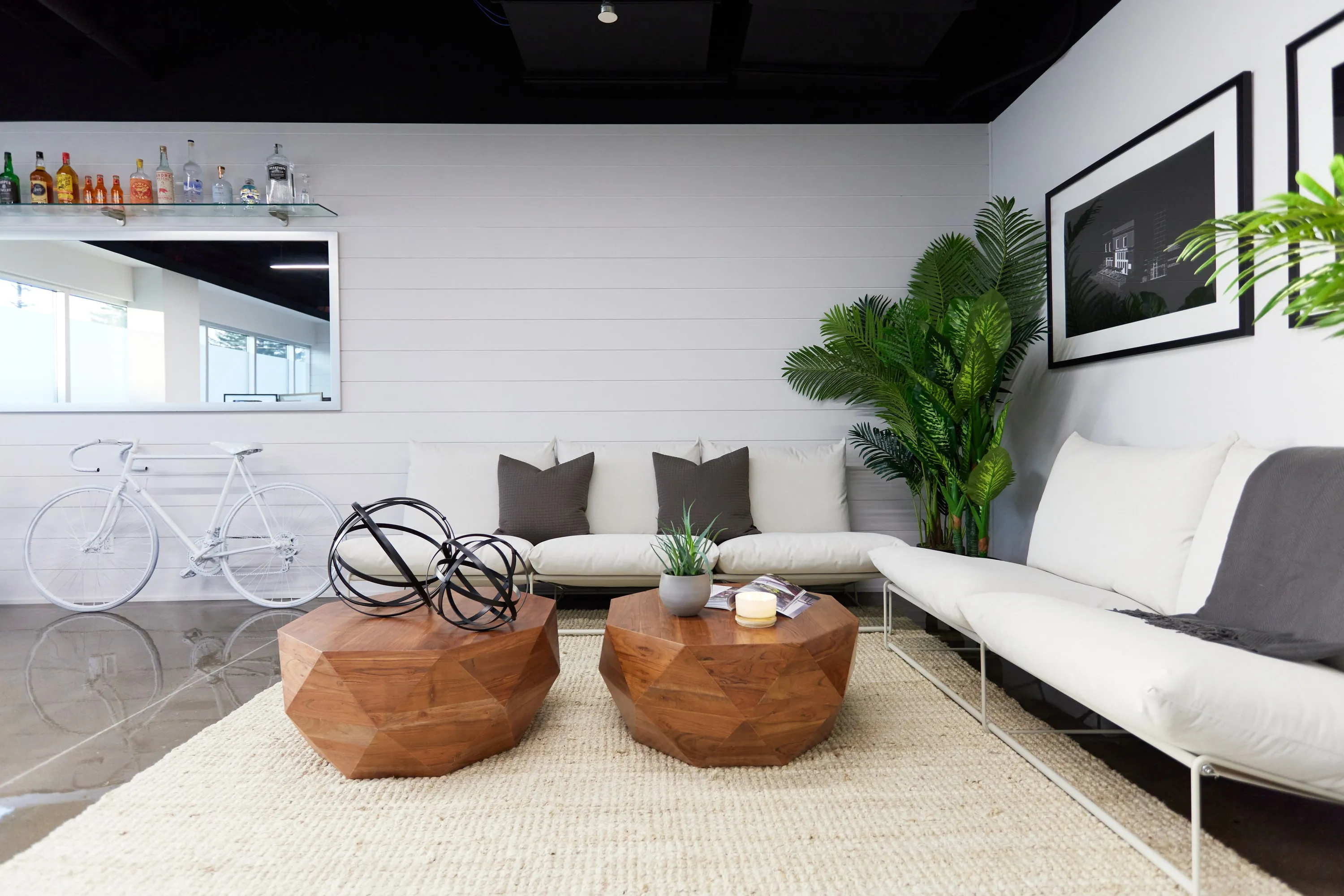 A white sofa and timber tables in the studio lounge.